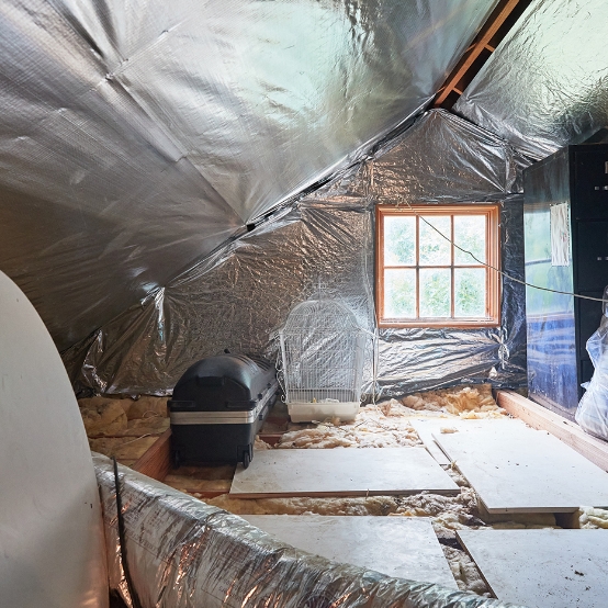 Overview of an attic with a radiant barrier and insulation installed