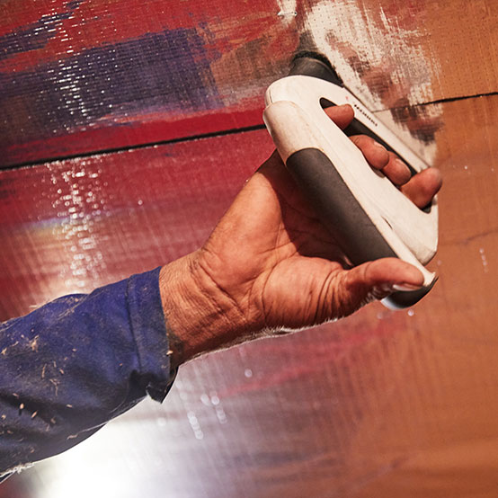 Closeup of a HeatBusters technician using a tool to install the radiant barrier.
